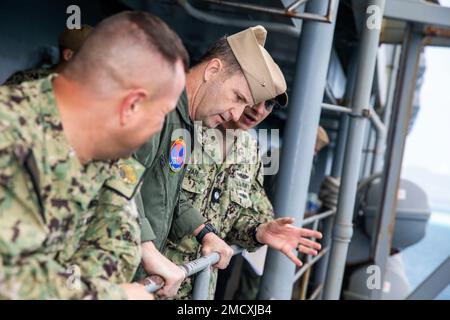 APRA-HAFEN, Guam – Cmdr. Bryan Kupyar, Right, Executive Officer des U-Boot-Tenderschiffs USS Emory S. Land (AS 39), gibt eine Schiffstour nach Rear ADM. Mark Melson, Center, Commander, Logistics Group Western Pacific/Commander, Task Force 73, Center, Juli 11. Land hat die Aufgabe, schnelle Wartungs- und Reparaturarbeiten auf mittlerer Ebene durchzuführen sowie Hotelservice und Logistikunterstützung für bereitgestellte geführte Raketen und Schnellangriff-U-Boote bereitzustellen, die in Zuständigkeitsbereiche der US-5.- und US-7.-Flotte eingesetzt werden. Stockfoto