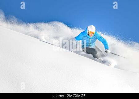 Ein Skifahrer auf einer scharfen Kurve in tiefem Pulverschnee abseits der Piste, während er frei reitet Stockfoto