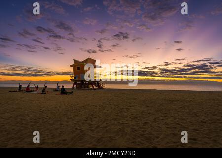 Sonnenaufgang in einem der berühmten Türme der Rettungsschwimmer mit einem Yoga-Team in Miami Beach, Florida, USA Stockfoto