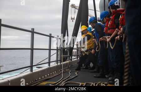 220712-N-XK047-1179 PAZIFIK (12. Juli 2022) – Seeleute bereiten sich darauf vor, mit dem Amphibien-Transportschiff USS John P. Murtha (LPD 26) auf dem Cockpit des Amphibien-Angriffsschiffs USS Makin Island (LHD 8) während eines Treibstoffes auf See Leinen zu schlagen. Die Makin-Insel ist im Juli 12 in der Lage, andere Schiffe für humanitäre Hilfe oder zur Unterstützung anderer militärischer Mittel während einer Mission mit Treibstoff zu versorgen und zu versorgen. Makin Island führt derzeit Routineeinsätze in der US-3.-Flotte durch. Stockfoto