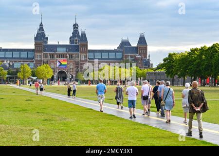 Amsterdam, Niederlande - August 2022: Menschen gehen durch einen Park in Richtung des berühmten Rijks-Museums im Stadtzentrum Stockfoto