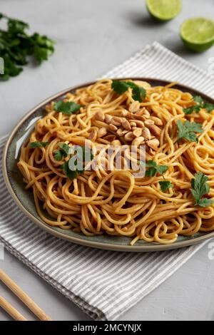Hausgemachte asiatische Erdnusssoße Nudeln auf einem Teller, Seitenansicht. Stockfoto