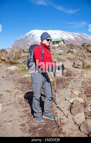 Männlicher Rucksacktourist auf der Wanderung zum Kilimandscharo-Berg. Stockfoto