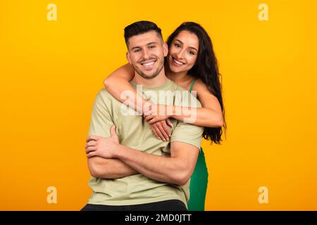 Eine glückliche junge Dame aus dem Nahen Osten in grünem Kleid, die ihren Freund umarmt, feiert das Party-Event Stockfoto