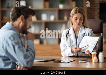 Arztfrau Diskutiert Medizinische Testergebnisse Mit Männlichem Patienten In Der Klinik Stockfoto