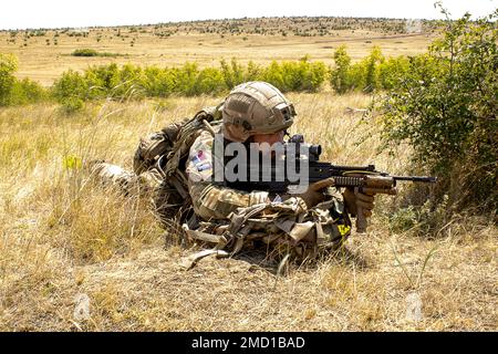 BABADAG-TRAININGSBEREICH, Rumänien. Ein Flugmann mit dem 140. Expeditionary Air Wing in Großbritannien bietet Sicherheit während der Personalbergungsschulung mit 3-227 AHB, 12. Juli 2022. Regelmäßige Interoperabilitätsschulungen mit NATO-Partnern und -Verbündeten schaffen Vertrauen und Bereitschaft und erhöhen die Abschreckungs- und Verteidigungskapazitäten. Stockfoto