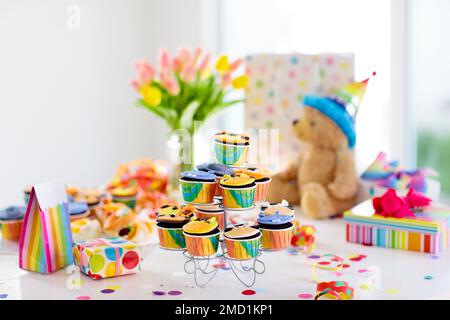 Cupcakes für Kinder Geburtstagsfeier. Kinderparty mit Dschungeltieren. Dekoriertes Zimmer für Jungen oder Mädchen Kindergeburtstage. Tischeinstellung mit Geschenken Stockfoto