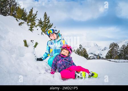 Familie, Mutter und Tochter bauen einen kleinen Schneemann neben der Skipiste. Skiurlaub im Winter in Andorra, El Tarter, Pyrenäen Stockfoto