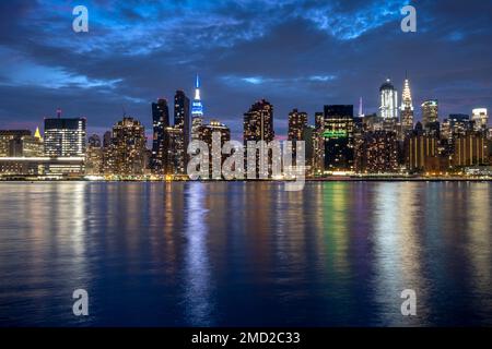 Manhattan Skyline bei Nacht mit dem Empire State Building auf der anderen Seite des East River, New York, USA Stockfoto