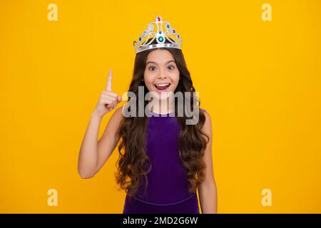 Kleine Königin mit goldener Krone. Teenager-Mädchen-Prinzessin mit Krontiara. Abschlussball-Party, Kindheitskonzept. Aufgeregtes Gesicht, fröhliche Emotionen Stockfoto