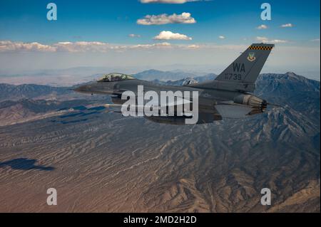 Ein F-16 Fighting Falcon, gesteuert von Captain Tim „REEF“ Joubert, Ausbilderpilot, der der 64. Aggressor-Staffel zugeteilt wurde, fliegt über den Test- und Trainingsbereich von Nevada, nachdem er an einer Red Flag-Nellis 22-3-Mission am Luftwaffenstützpunkt Nellis am 12. Juli 2022 teilgenommen hatte. Die Nevada Test and Training Range ist die USA Das führende militärische Trainingsgebiet der Air Force mit mehr als 12.000 Quadratkilometern Luftraum und 2,9 Millionen Hektar Land. Stockfoto