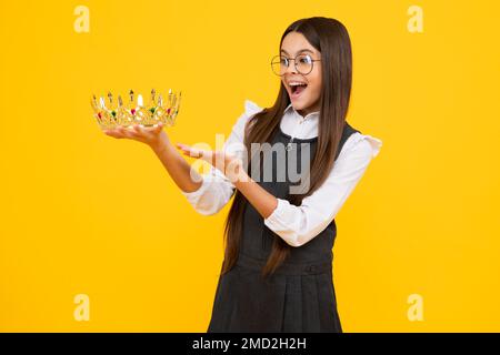 Kleine Königin mit goldener Krone. Teenager-Mädchen-Prinzessin mit Krontiara. Abschlussball-Party, Kindheitskonzept. Aufgeregtes Gesicht, fröhliche Emotionen Stockfoto