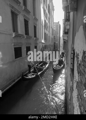 31. Oktober 2022 - Venedig, Italien: Schwarzweißfoto von zwei Gondeln in einem Kanal von Venedig. Tourismuskonzept. Stockfoto