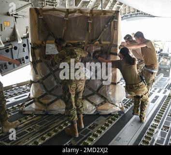 Die Luftwaffe des 386. Expeditionary Logistics Readiness Squadron sowie die l816. Expeditionary Airlift Squadron Loadmasters positionieren die Fracht an Bord eines C-17 Globemaster-Flugzeugs am 12. Juli 2022 auf dem Ali Al Salem Air Base, Kuwait. Die dem Al-Udeid-Luftwaffenstützpunkt Katar zugeteilte C-17 transportierte die Fracht zu anderen Stützpunkten in der Region. Stockfoto