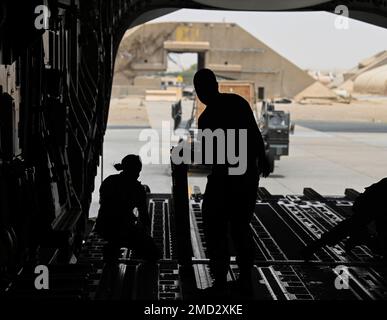 Flugzeuge des 386. Expeditionary Logistics Readiness Squadron bereiten sich darauf vor, Fracht auf ein C-17 Globemaster-Flugzeug zu laden, das der Al Udeid Airbase Katar am 12. Juli 2022 in der Ali Al Salem Air Base, Kuwait, zugewiesen ist. Die 386. ELRS-Flugzeuge haben mit C-17-Ladermastern zusammengearbeitet, um Fracht an Bord des Flugzeugs zu laden. Stockfoto