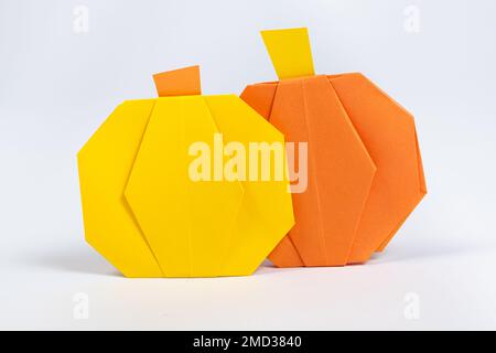 Halloween DIY Origami – Gelbe und orangefarbene Papierkürbis auf weißem Hintergrund Stockfoto