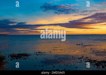 Wunderschöner Sonnenuntergang in den letzten Momenten der Goldenen Stunde, reflektiert über die Gewässer von Lough Neagh, Nordirland Stockfoto