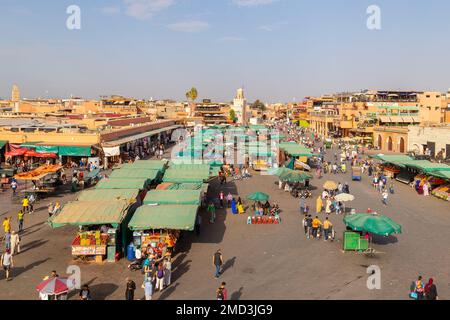 MARRAKESCH, MAROKKO - 3. NOVEMBER 22: Teil des Jamaa el Fna Markts im Zentrum von Marrakesch während des Tages. Ställe und Menschen können gesehen werden. Stockfoto