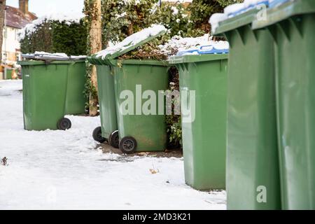 Im Winter gibt es in London nach dem Schnee viele Mülltonnen auf der Straße Stockfoto