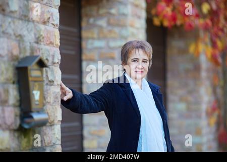 Porträt einer älteren Frau auf der Straße im Herbst Stockfoto