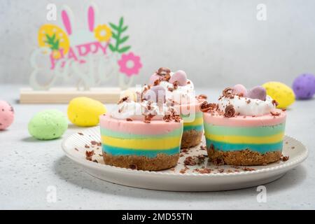 Ostern-Mini-Käsekuchen mit Zuckereiern und Schlagsahne. Stockfoto