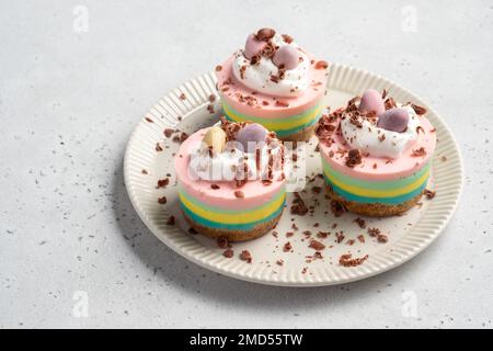 Ostern-Mini-Käsekuchen mit Zuckereiern und Schlagsahne. Stockfoto