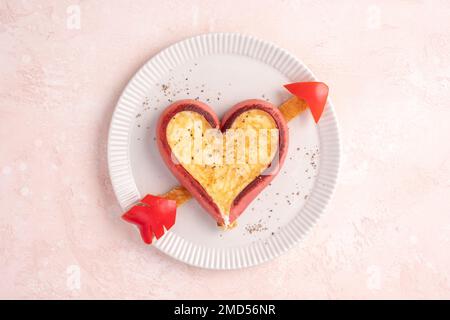 Romantisches Frühstück. Spiegeleier in herzförmigen Würstchen Stockfoto