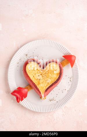 Romantisches Frühstück. Spiegeleier in herzförmigen Würstchen Stockfoto