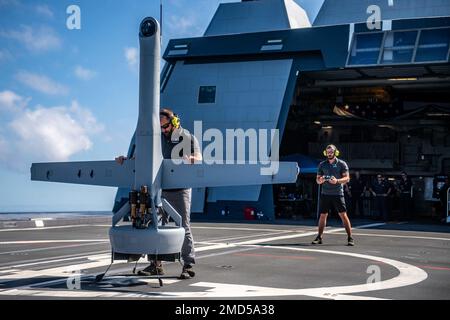 220713-N-YN807-1018 PAZIFIK (13. Juli 2022) – US-amerikanische Auftragnehmer bereiten sich auf den Start von V-BAT 118 für den ersten Flug an Bord des Guided Missile Destroyers USS Michael Monsoor (DDG 1001) während Rim of the Pacific (RIMPAC) 2022, Juli 13 vor. Von Juni 29 bis August 4 nehmen an der RIMPAC auf und um die hawaiianischen Inseln und Südkalifornien 26 Nationen, 38 Schiffe, vier U-Boote, mehr als 170 Flugzeuge und 25.000 Mitarbeiter Teil. RIMPAC ist die weltweit größte internationale Seefahrt-Übung und bietet eine einzigartige Ausbildungsmöglichkeit bei gleichzeitiger Förderung und Aufrechterhaltung der kooperativen Beziehungen zwischen den Beteiligten Stockfoto