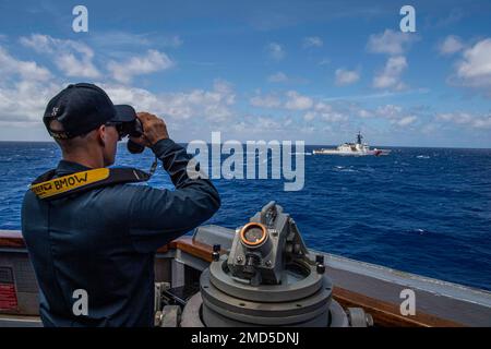 PACIFIC OCEAN (13. Juli 2022) Boatswain's Mate 1. Class John Fahlgren steht als US-amerikanischer Wächter Coast Guard Legend-Class Cutter USCGC Midgett (WMSL 757) segelt während Rim of the Pacific (RIMPAC) 2022 neben dem Arleigh Burke-Class Guided Missile Destroyer USS Chafee (DDG 90). Von Juni 29 bis August 4 nehmen an der RIMPAC 25.000 Nationen, 38 Schiffe, vier U-Boote, mehr als 170 Flugzeuge und Mitarbeiter auf und um die hawaiianischen Inseln und Südkalifornien Teil. RIMPAC ist die weltweit größte internationale Seefahrt-Übung und bietet einzigartige Schulungsmöglichkeiten bei gleichzeitiger Förderung und Nachhaltigkeit Stockfoto