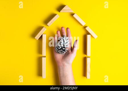 Kegel mit Kinderhänden. Haus aus Holzblöcken. Schließen. Draufsicht. Stockfoto