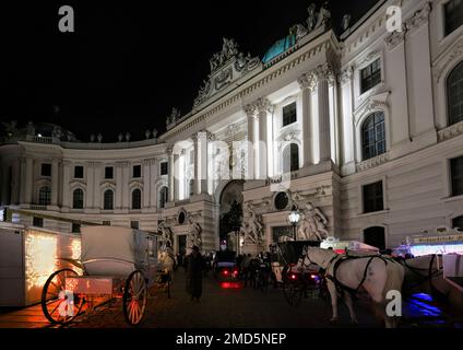 Wien, Osterreich, 2019. Dez.: Nachtsicht auf die Hofburg auf St. Michael Square (Michaelerplatz) am weihnachtsabend mit Pferdekutsche