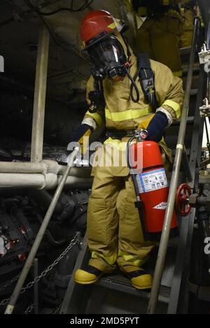 220713-N-N3764-1004 OSTPAZIFIK (13. Juli 2022) Boatswain's Mate 2. Klasse Chadwick Lambert trägt einen Feuerlöscher während einer simulierten Hauptraum-Feuerübung an Bord des Kampfschiffs USS Billings (LCS 15) der Freiheitsvariante USS Billings (LCS), 13. Juli 2022. Billings wird in das US-Flottengebiet 4. entsandt, um die Mission der Joint Interagency Task Force South zu unterstützen, zu der auch Missionen zur Bekämpfung des illegalen Drogenhandels in der Karibik und im östlichen Pazifik gehören. Stockfoto