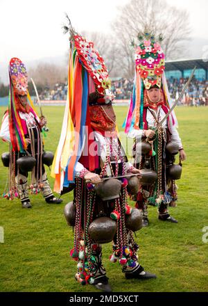 Typische Kukeri Startsi-Tänzer mit aufwendig gestickten Kostümen und großen Glocken beim jährlichen Simitlia Winter Festival in Simitli, Bulgarien, EU Stockfoto