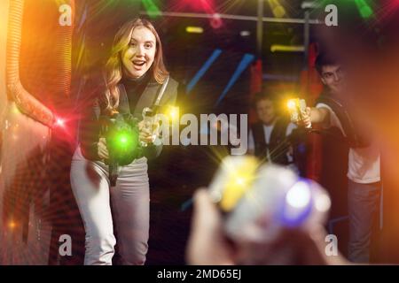 Junge Dame hat Spaß beim Lasertag in der Arena Stockfoto