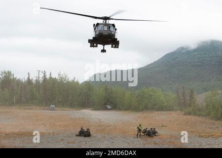 Ein Alaska Army National Guard UH-60L Black Hawk, der von einer dem 1. Bataillon, dem 207. Lufttruppenkommando, zugeteilten Besatzung betrieben wird, startet nach dem Transport von Offizieren des Special Weapons and Tactics (SWAT)-Teams der Polizei von Anchorage auf der Gemeinsamen Basis Elmendorf-Richardson, Alaska, 13. Juli 2022. Die ausgedehnten und strengen Ausbildungsbereiche von JBER boten den idealen Rahmen für örtliche Einsatzteams der Strafverfolgungsbehörden, da sie ihre Fähigkeiten im ländlichen Bereich, Aufgabenplanung, Aufklärung, Sicherheitsverfahren für Hubschrauber, Landnavigation, Team-Bewegung und Patrouille. Stockfoto