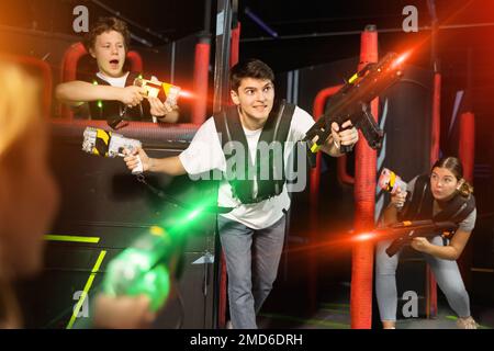Drei Leute haben Spaß beim Lasertag in der Arena Stockfoto
