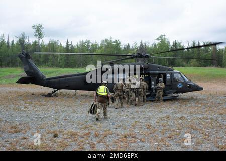 Spezialagenten des Anchorage FBI Special Weapons and Tactics (SWAT)-Teams gehen an Bord einer Alaska Army National Guard UH-60L Black Hawk, die von einer Besatzung betrieben wird, die dem 1. Bataillon, 207. Luftfahrt-Truppenkommando, auf der gemeinsamen Basis Elmendorf-Richardson, Alaska, am 13. Juli 2022, zugewiesen ist. Die ausgedehnten und strengen Ausbildungsbereiche von JBER boten den idealen Rahmen für örtliche Einsatzteams der Strafverfolgungsbehörden, da sie ihre Fähigkeiten im ländlichen Bereich, Aufgabenplanung, Aufklärung, Sicherheitsverfahren für Hubschrauber, Landnavigation, Team-Bewegung und Patrouille. Stockfoto