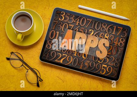 Apps (Anwendungen) Wort in Vintage Buchdruck Holzart Nummer Hintergrund auf digitale Tablett mit Kaffee - Softwarekonzept Stockfoto
