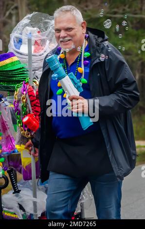 Bei der Mardi Gras-Parade auf Dauphin Island, Alabama, verkaufen Straßenverkäufer Blasengewehre und andere Schmuckstücke. Stockfoto