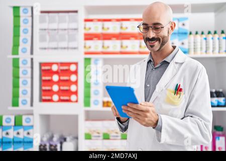 Junger hispanischer Apotheker mit Touchpad in der Apotheke Stockfoto