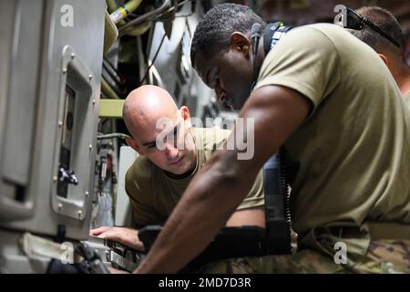 Tech. Sgt. Joshua Watkins und Senior Airman James Jefferson von der 172. Maintenance Group, Jackson, Mississippi, Referenzkommunikation, Navigation, Und Handbücher für Überwachungssysteme bei der Fehlersuche an einem C-17 Globemaster III-Flugzeug am Air Station Barber's Point, Hawaii, 13. Juli 2022. Die 183. Airlift Squadron, die 172. Maintenance Group und der 186. Air Tanken Wing führten an Bord Tankstellen und andere Schulungsszenarien durch, um ihre Fähigkeiten weiter zu verbessern. USA Air National Guard Foto von LT. Colonel Reagan B. Lauritzen. Stockfoto