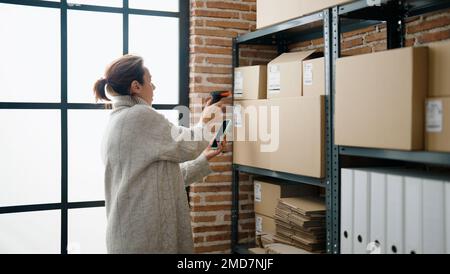 Mittelalter hispanische Frau E-Commerce-Business-Arbeitnehmer Scannen Paket mit Barcode-Leser im Lagerhaus Büro Stockfoto