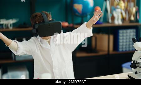 Süßer hispanischer Junge mit Virtual-Reality-Brille im Labor Stockfoto