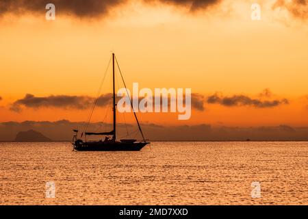 Segelboot mitten im Sonnenuntergang Stockfoto