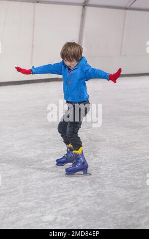 Der kleine macht gerne Schlittschuhlaufen auf Eis Stockfoto