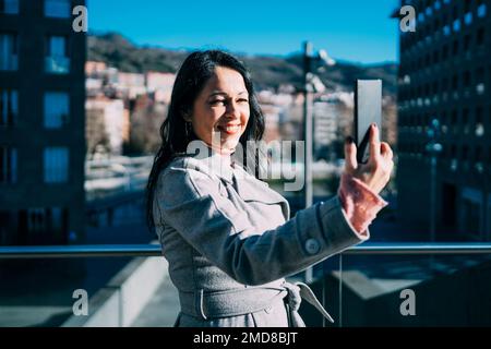 Eine Geschäftsfrau, die eine Videokonferenz auf der Straße macht. Geschäftsfrau-Konzept Stockfoto