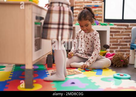 Zwei Kinder spielen mit Spielküche und Mathematik-Puzzle-Spiel im Kindergarten Stockfoto