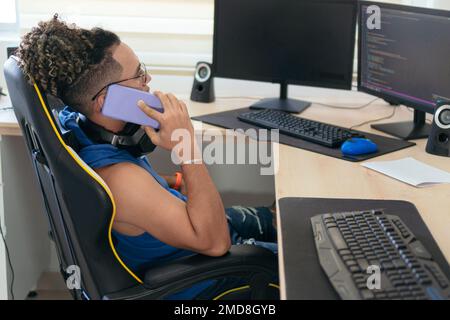 Ein Mann, Der Telefoniert, Während Er Zu Hause Am Tisch Sitzt Stockfoto