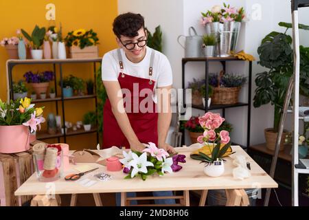 Nicht binärer männlicher Florist macht Blumenstrauß im Blumenladen Stockfoto